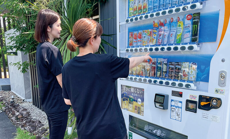 自動販売機で、飲み物を選んでいる様子